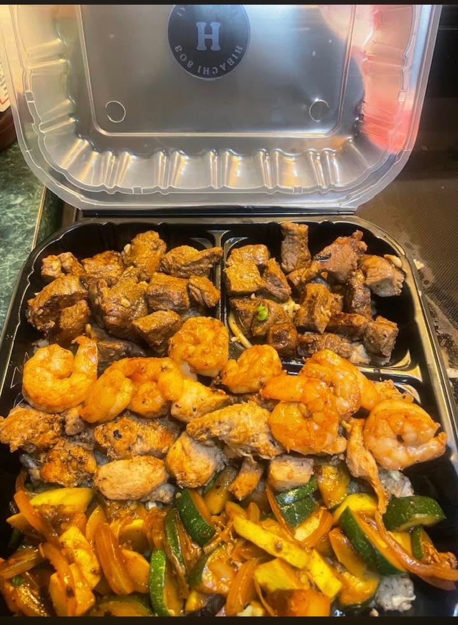 Trio hibachi tray with steak, chicken, shrimp, rice, and grilled vegetables