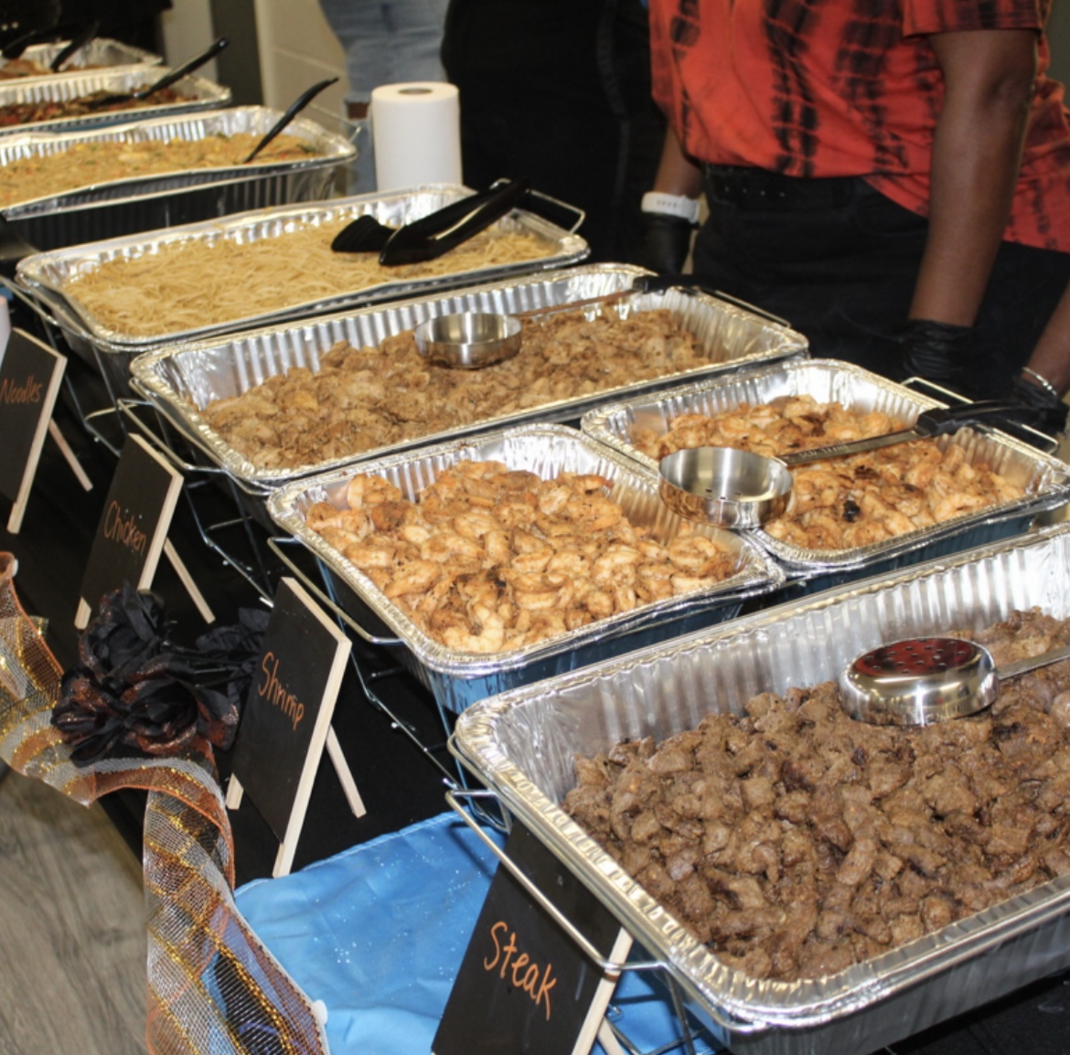 Catering trays with chicken, shrimp, steak, and noodles